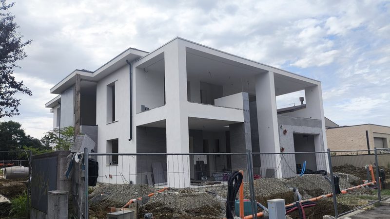 Edificio residenziale al grezzo con struttura in cemento armato, logge e sbalzi, in fase di cantiere.
